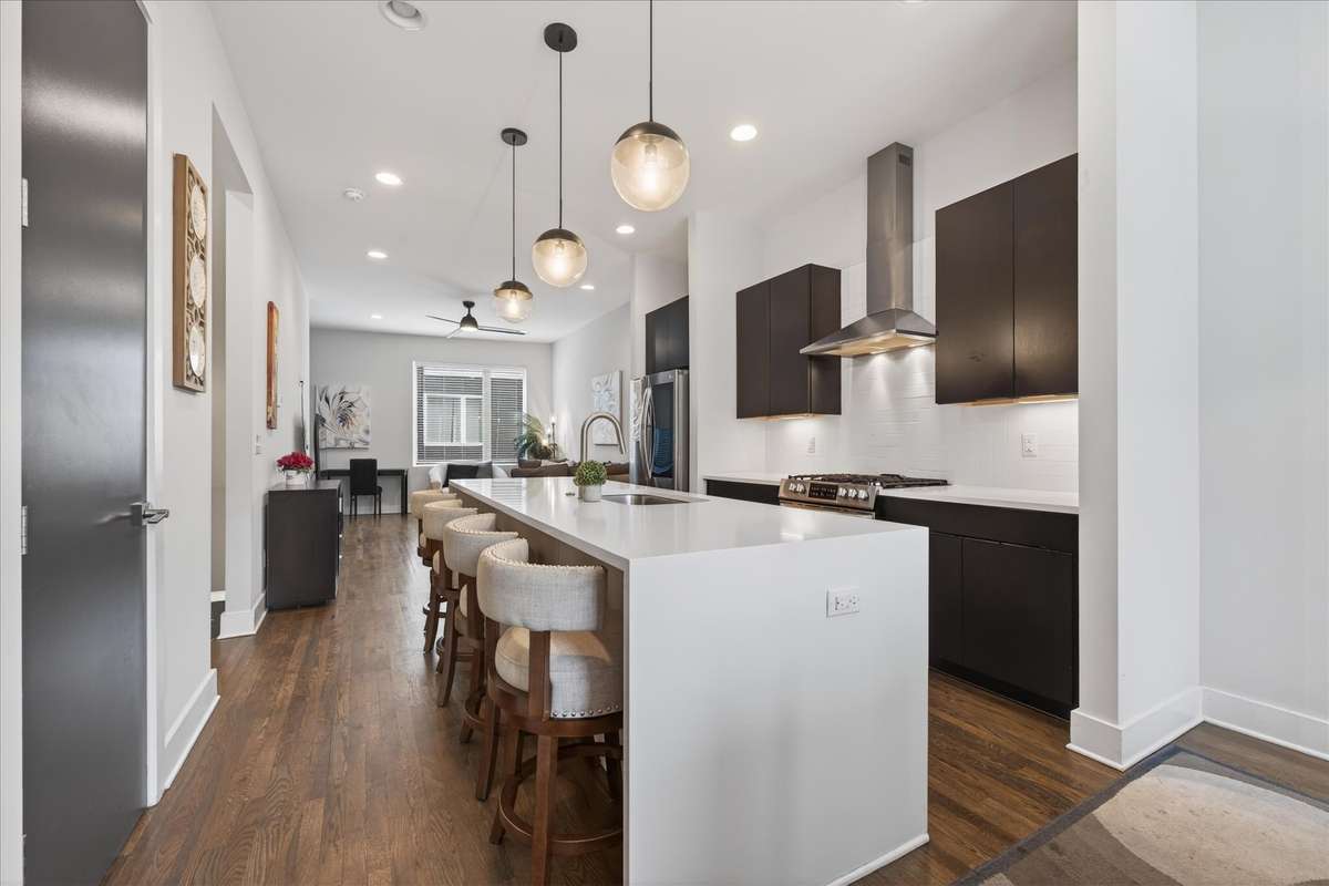 Gather around the stunning waterfall island—a centerpiece of the kitchen, perfect for casual dining, prepping meals, or entertaining guests in style.