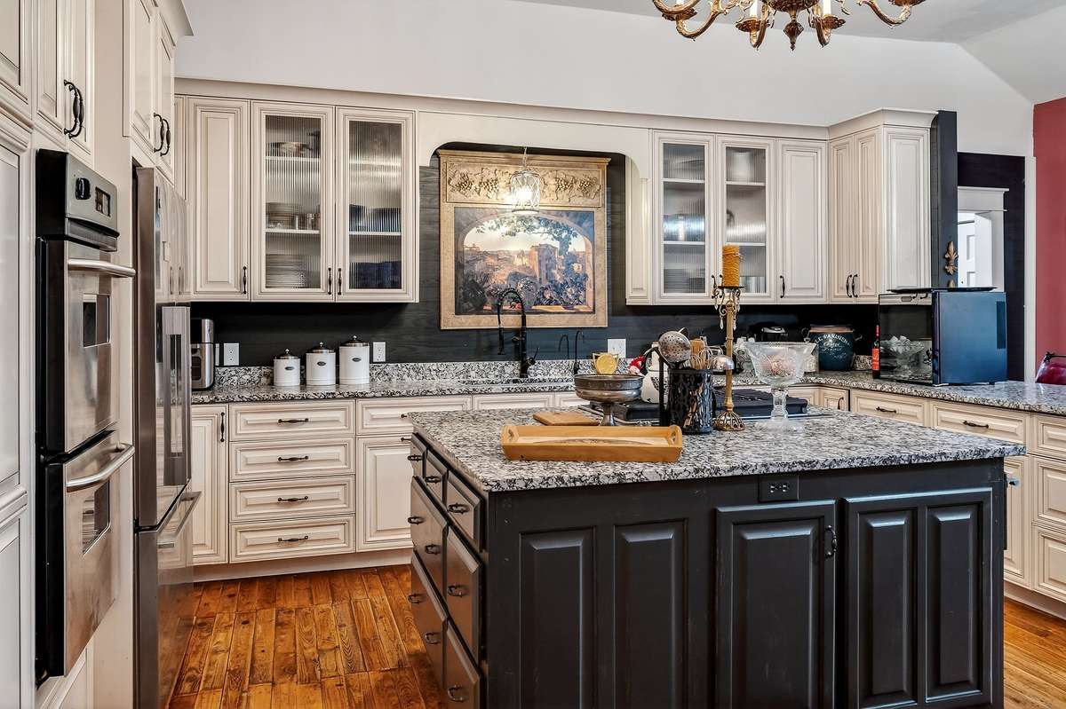 The living room opens up to this beautiful kitchen with pearl color cabinets with soft touch closure drawers and cabinets, granite countertops, and a beautiful island with natural gas cooktop.