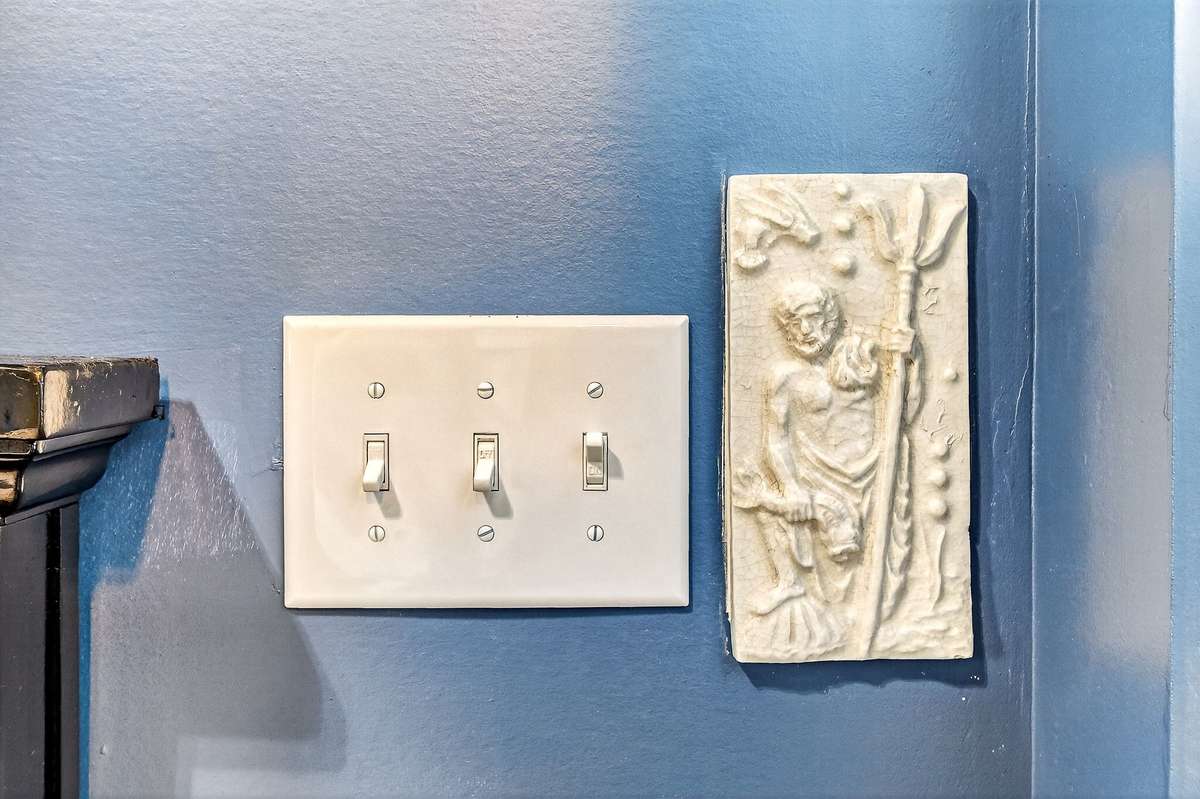 Little features like this Greek ocean god Poseidon tiles next to the light switches.