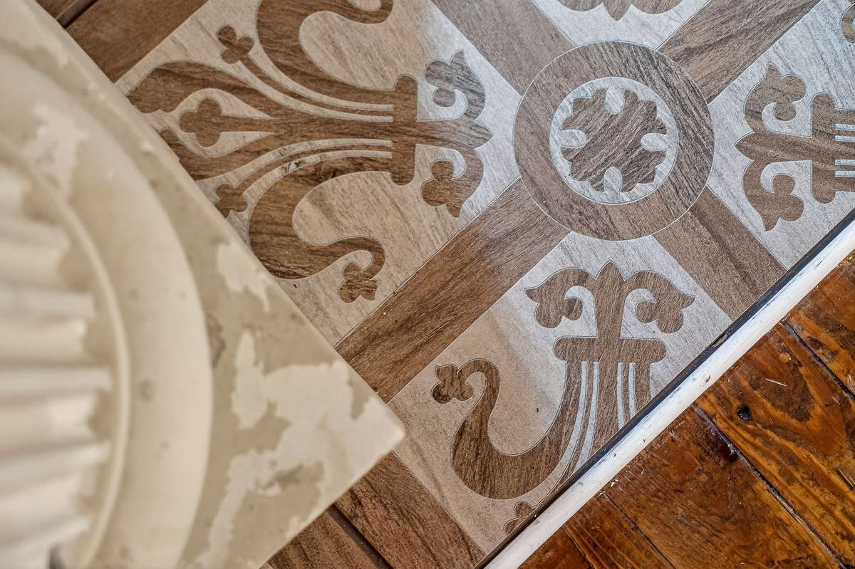 The front entrance vintage French door opens up to a marble slab enveloped with porcelain tile with Knights Templar cross of St. Thomas . These tiles are features in 2 other rooms.