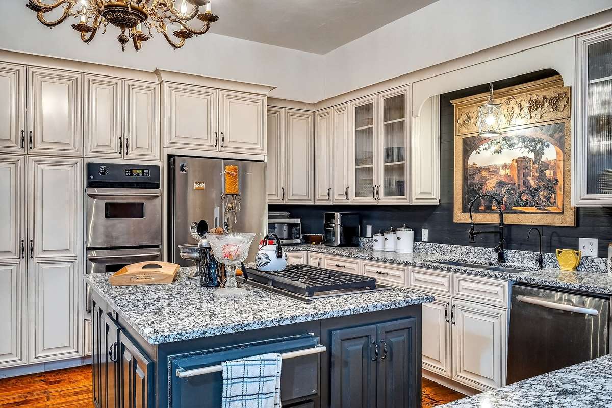 Lots of storage, style and space compliment this large kitchen. Stainless steel appliances remain. These consists of double oven, cooktop, refrigerator, and dishwasher. A microwave also remains.