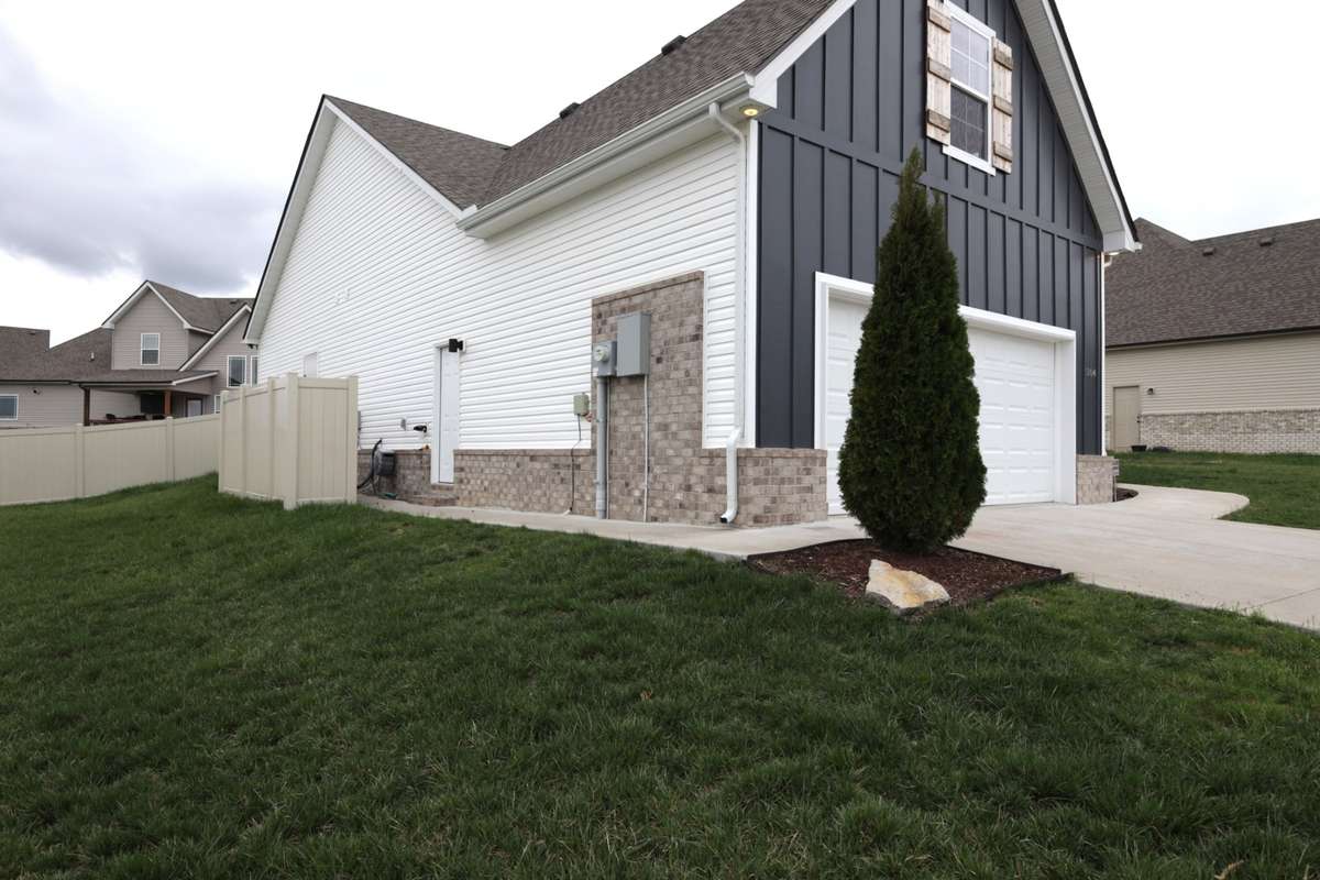 Paved walkway to garage side entry door with a vanity fence.
