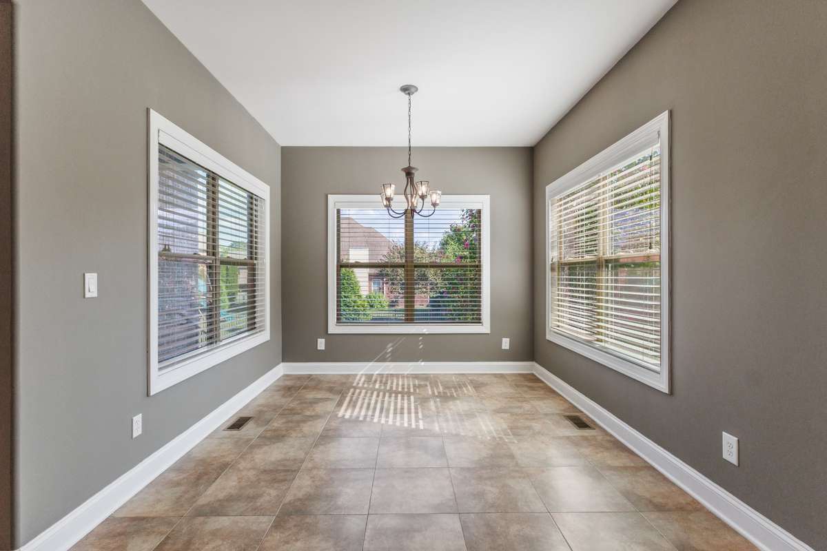Inviting breakfast nook surrounded by windows and light, ideal for family meals or quiet mornings.