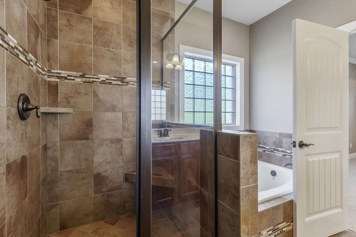 The spa-inspired bathroom offers a tile walk-in shower creating the perfect sanctuary for rest and relaxation.