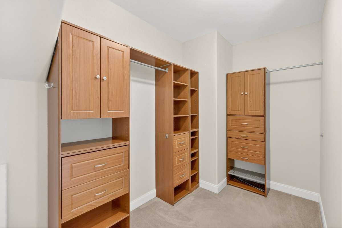 Custom Built-Ins in Primary Closet. Hanging space, drawers and open shelves. Great space for organizing all of your clothes, purses, shoes, etc.