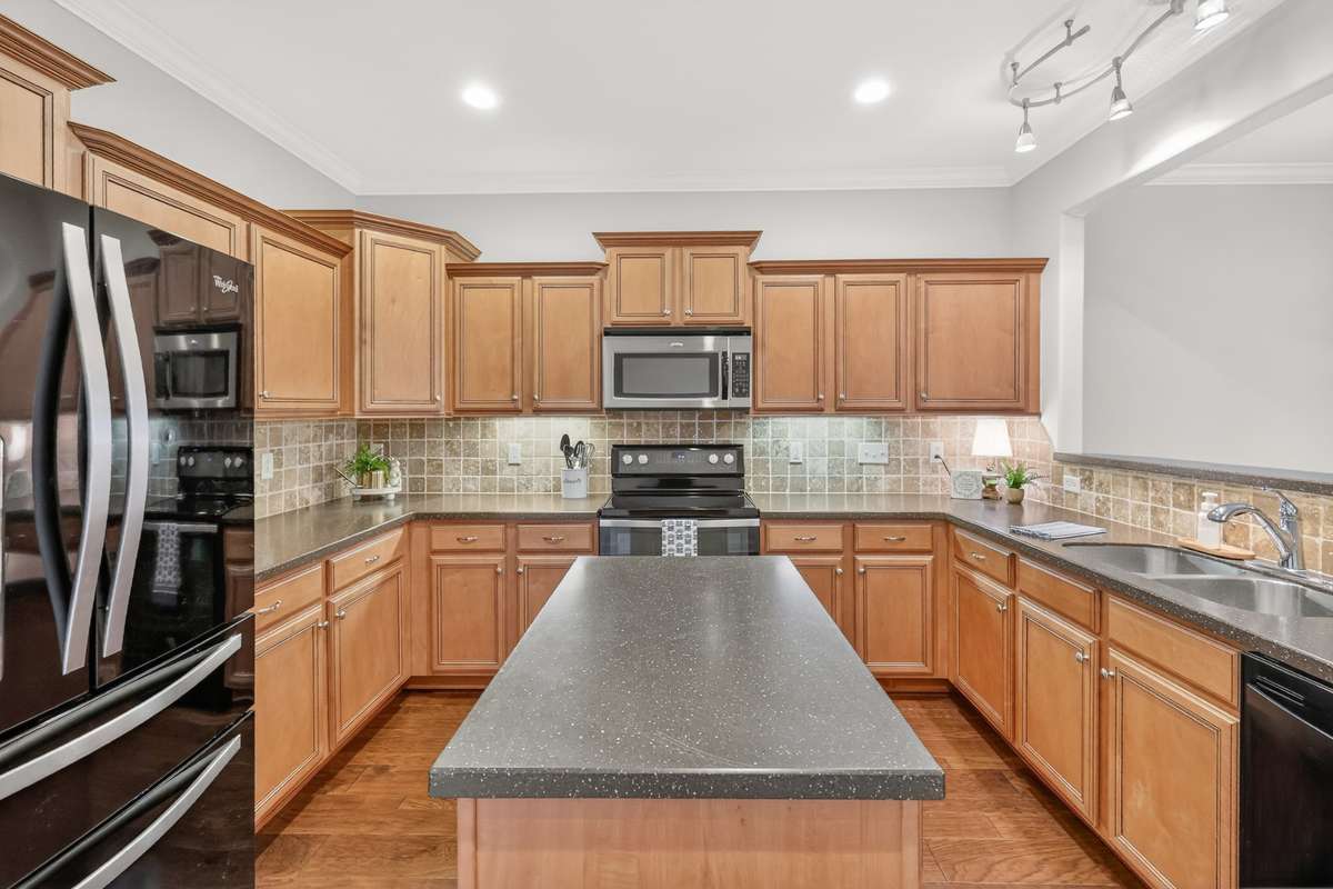 Refrigerator, microwave, stove and dishwasher stay! Recessed and under cabinet lighting add to the functionality of this great kitchen.