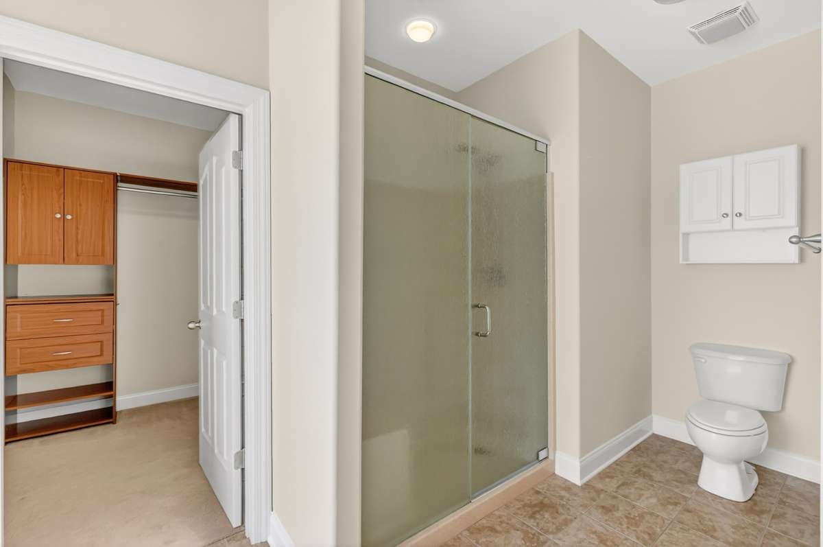 Nice size shower with bench seat and handheld showerhead.