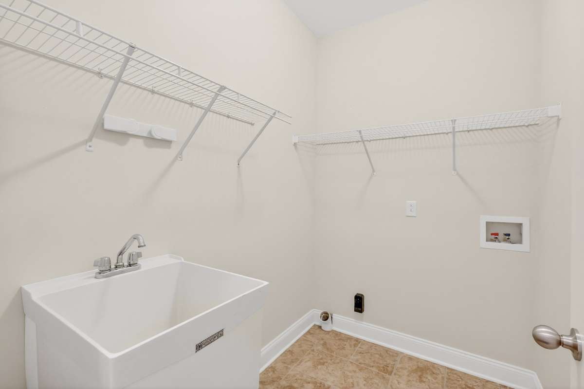 Laundry Room with ample shelving and deep utility sink.