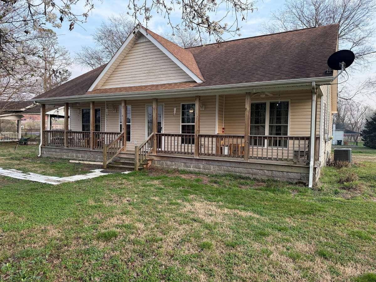 Front of house- covered porch with railings, vinyl siding