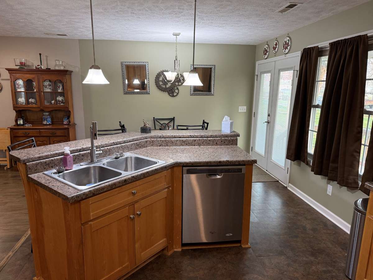 Kitchen- laminate flooring, bar seating, dining area, wood cabinetry