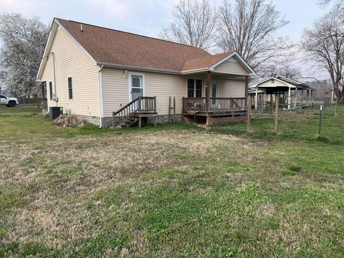 Back of house- vinyl siding, covered porch, partially fenced
