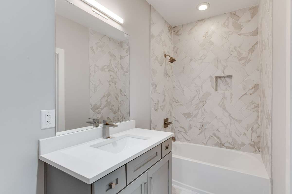 Main floor private full bathroom, designer tile & soft-close drawers and cabinets