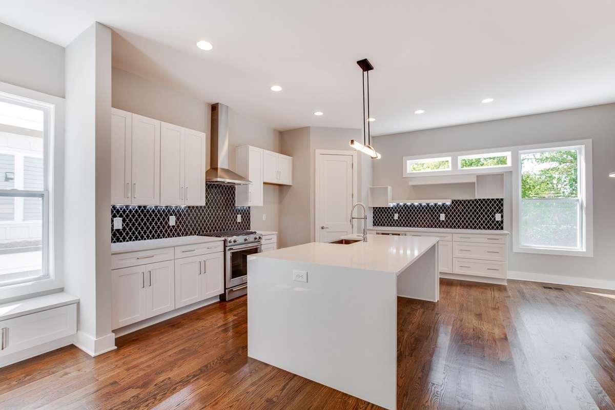 Beautiful entertaining kitchen. Quartz waterfall island, under cabinet lighting and abundant storage