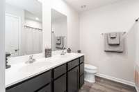Primary bathroom with dual sinks and convenient tub/shower combo