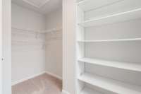 Spacious primary walk in closet with custom shelving