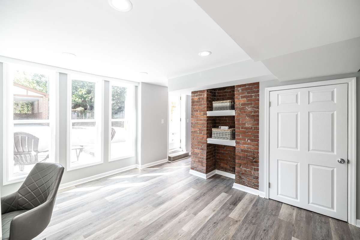 Natural light highlights the beauty of the exposed brick, giving this basement a warm and welcoming feel perfect for a variety of uses.