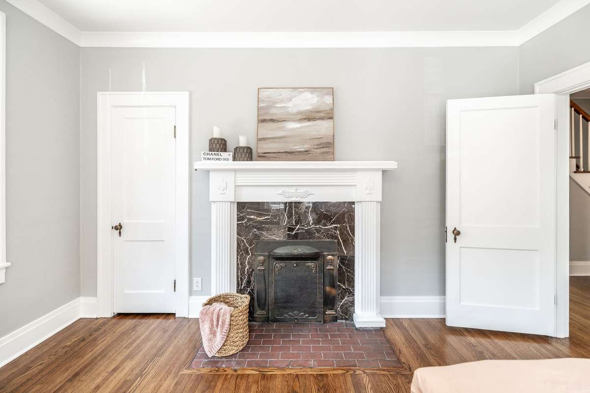 The original fireplace serves as a charming focal point, blending historic detail with the updated home