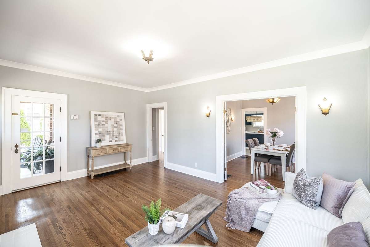 A wide view of the living area shows how the hardwood floors flow seamlessly, enhancing the home’s classic feel.