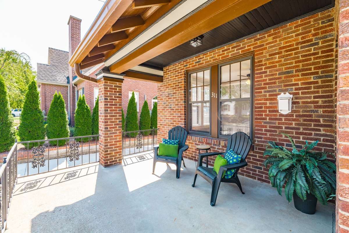 A closer view of the wide front porch, perfect for enjoying morning coffee or greeting neighbors as they stroll the historic district sidewalks.