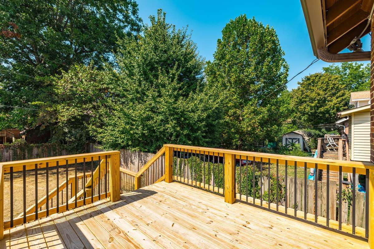 Brand-new deck with modern railing, perfect for outdoor gatherings and overlooking the backyard.