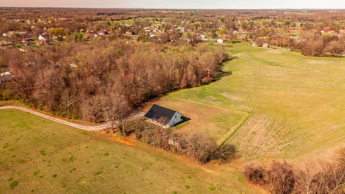 Welcome Home – Tucked behind a natural tree line on 1.35 peaceful acres, this beautiful modern farmhouse welcomes you with a long driveway, a full-length rocking chair front porch, and a setting that perfectly captures the charm of country living.