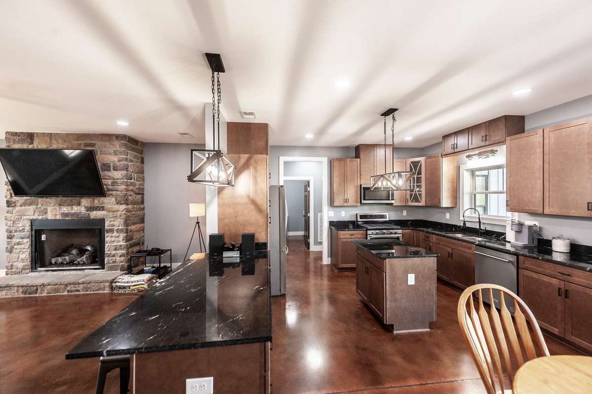 This spacious kitchen combines style and functionality with stained cabinetry, granite countertops, stainless steel appliances, and plenty of room for everyday meals.
