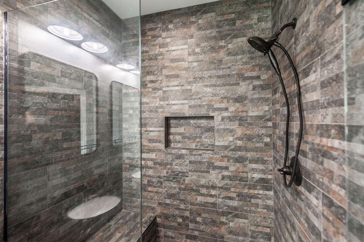 A large tiled shower with glass enclosure adds a modern touch and plenty of room to refresh.