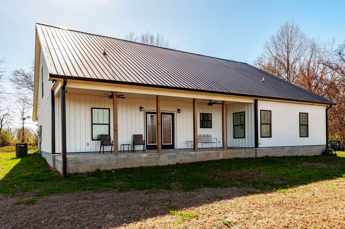 The large covered back porch is the perfect place to relax, unwind, and enjoy the peaceful rural setting.
