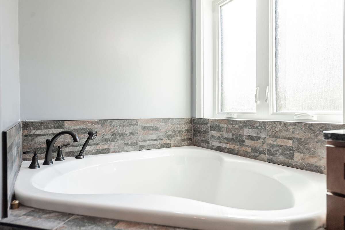 The spa-like primary bath features a luxurious soaking tub, perfect for unwinding after a long day.