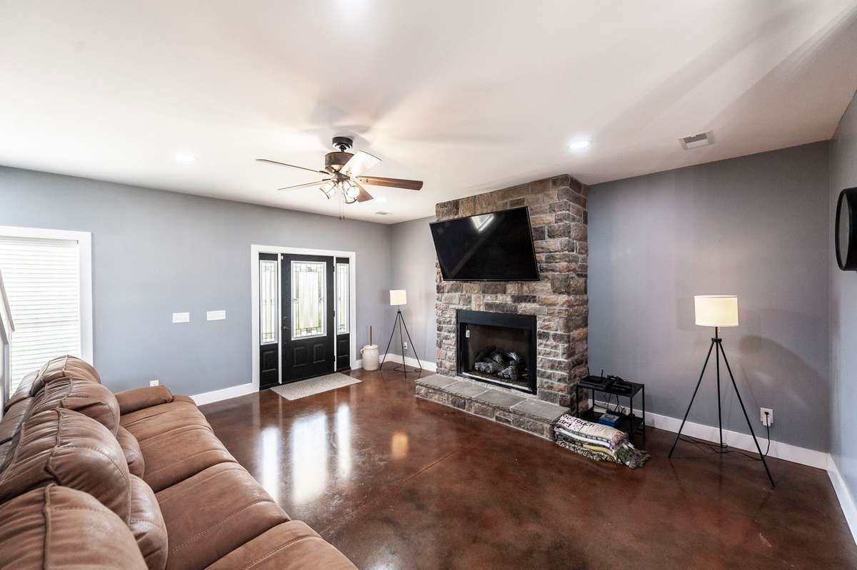 The floor-to-ceiling stone fireplace creates a stunning focal point and adds warmth and character to the main living area.