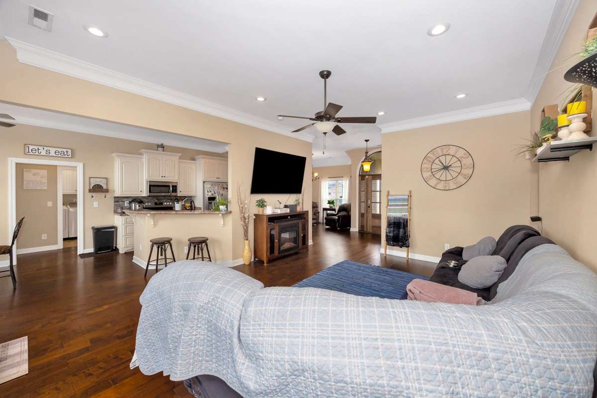 Living Room- Wood flooring, crown molding, ceiling fan, recessed lighting, 10'ceiling