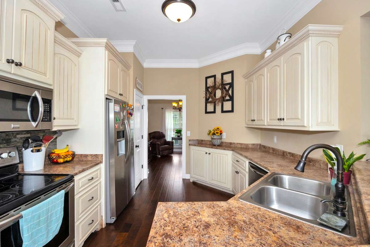 Kitchen- Wood flooring, pantry, crown molding, eat-in kitchen, 10' ceiling, dishwasher, microwave, refrigerator
