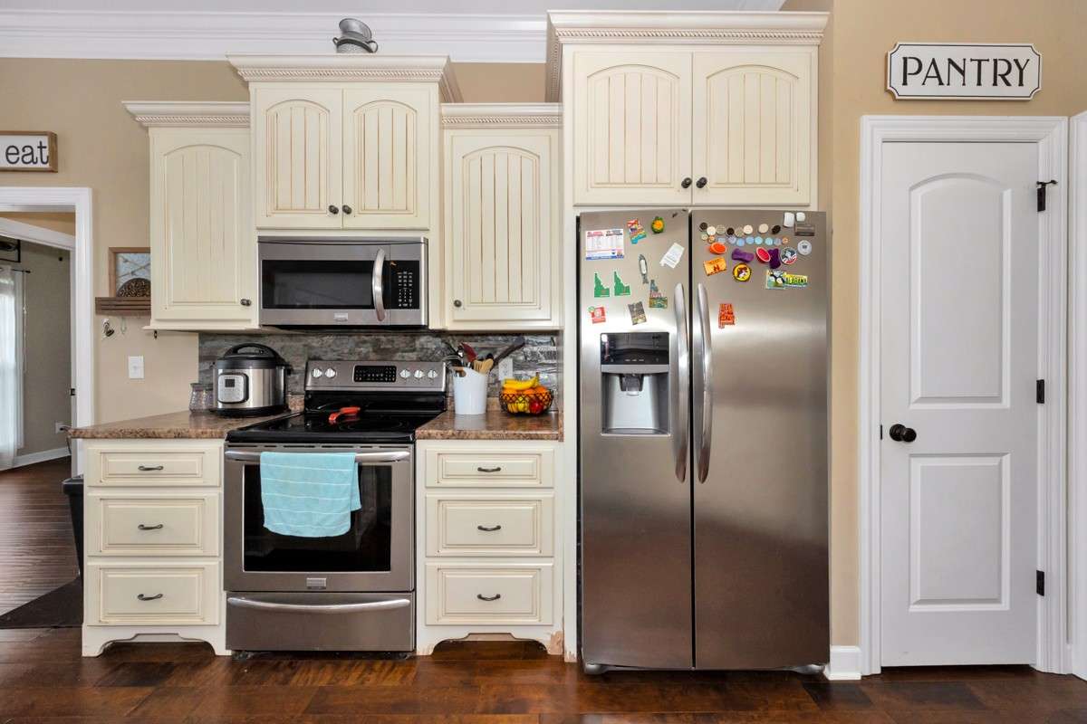 Kitchen- Wood flooring, pantry, crown molding, eat-in kitchen, 10' ceiling, dishwasher, microwave, refrigerator