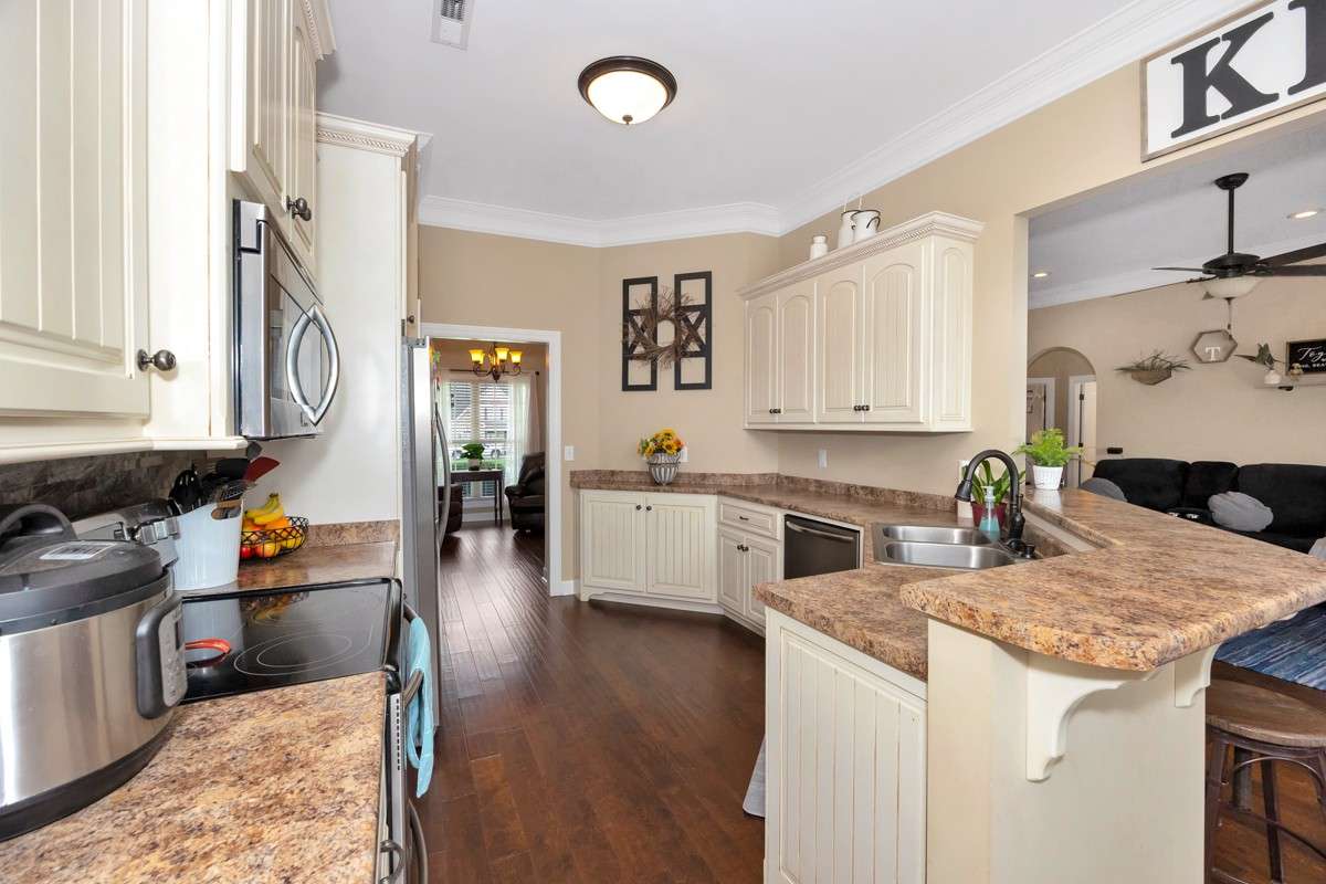 Kitchen- Wood flooring, pantry, crown molding, eat-in kitchen, 10' ceiling, dishwasher, microwave, refrigerator