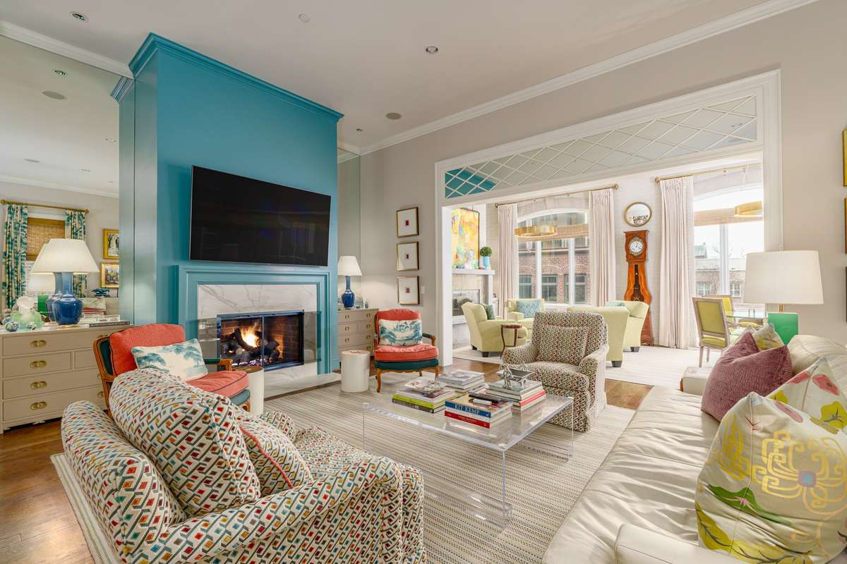 Cozy up  near the fireplace in this lovely living room that opens to the light and airy sunroom