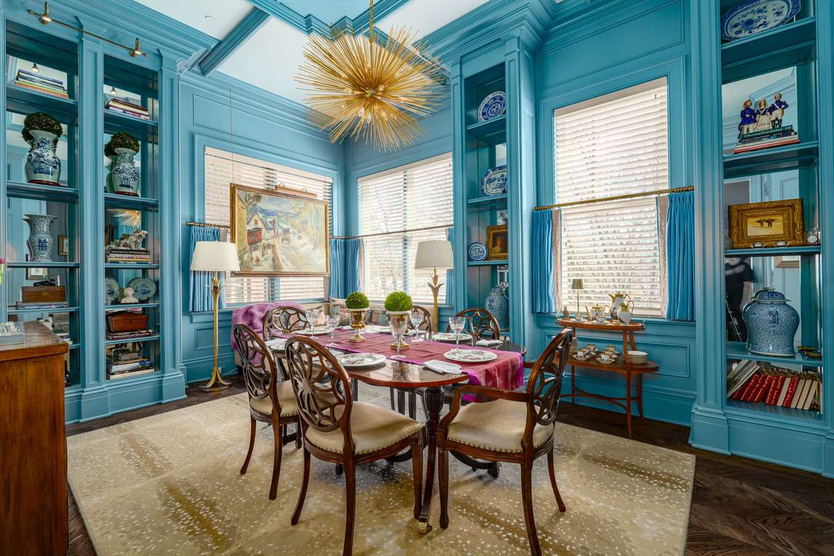 A real showstopper - this gorgeous dining room features amazing trim, built ins, mirrored wall, and designer lighting