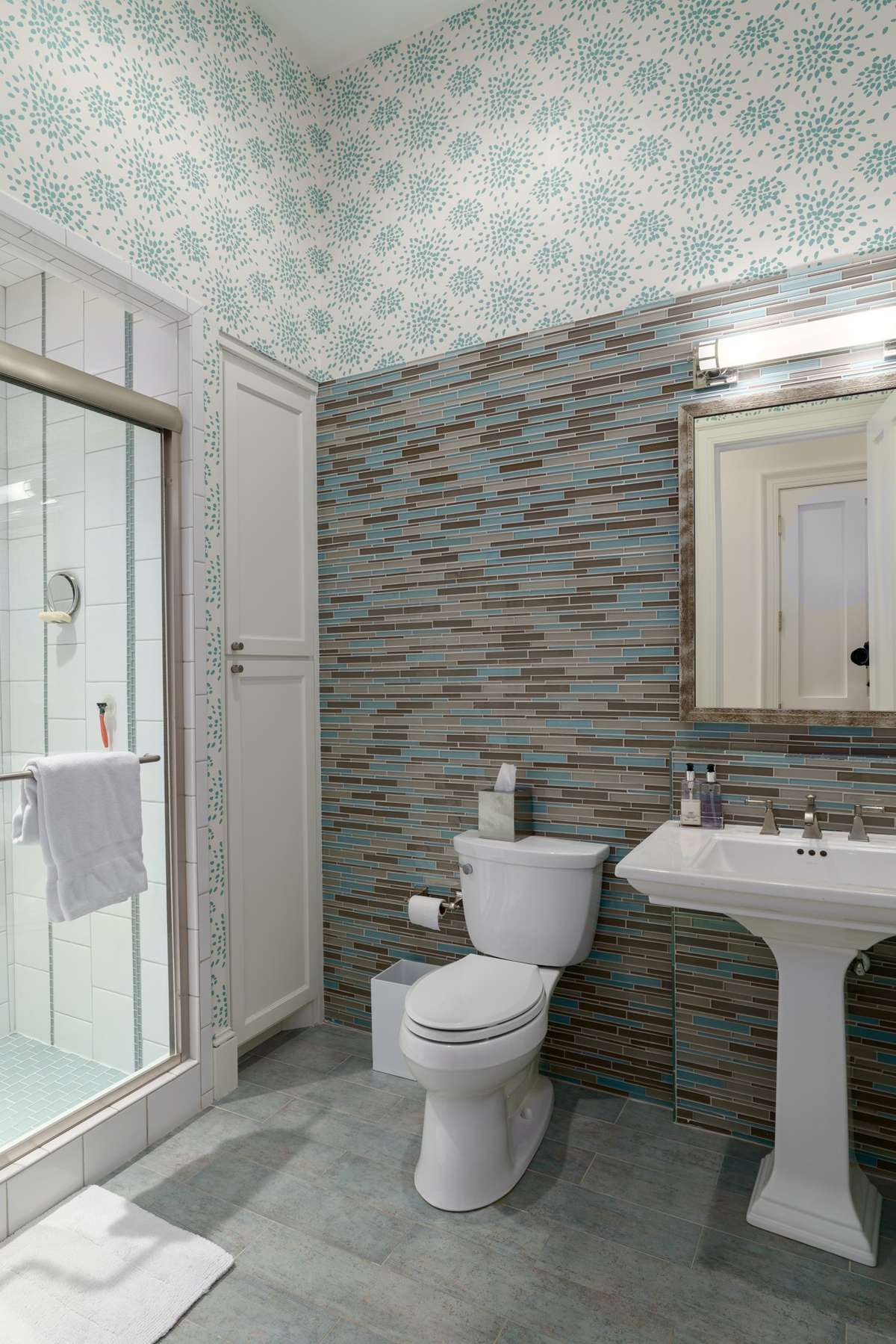 Full bath on lower floor features great looking tile and wallpaper.