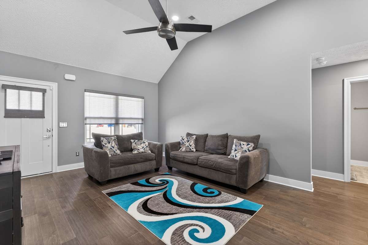 Vaulted ceiling with a ceiling fan keeps the air moving while gray walls and dark wood floors create a clean backdrop for any furniture style.