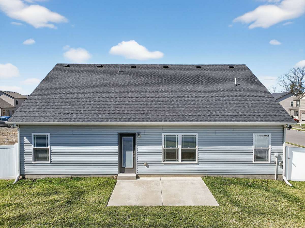 Fenced backyard with a sodded lawn and concrete patio that extends the living space outside.