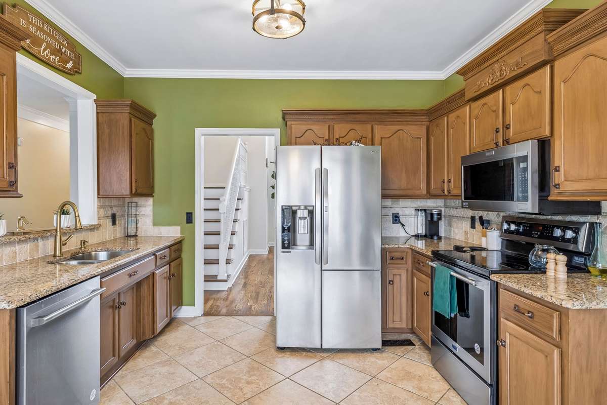Well-appointed kitchen with granite countertops, stainless steel appliances, tile flooring, and abundant cabinetry for storage! 1407 Ottawa Place, Murfreesboro, TN 37129
