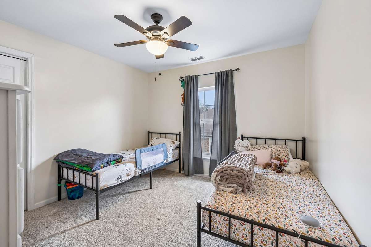 Comfortable secondary bedroom with soft carpeting, ceiling fan, and a large window that fills the space with natural light! 1407 Ottawa Place, Murfreesboro, TN 37129