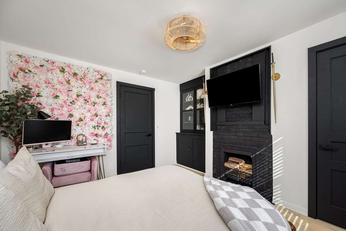 The primary bedroom features a fireplace, built-in glass cabinet and lots of beautiful details.