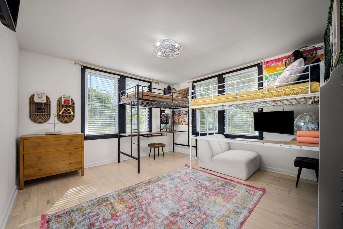 Bed 2 is a great size and features two sets of double windows for tons of natural light and hardwood floors.