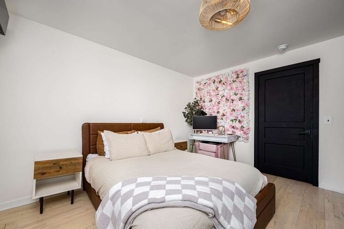 Another look at the primary bedroom. Hardwood floor and updated lighting.
