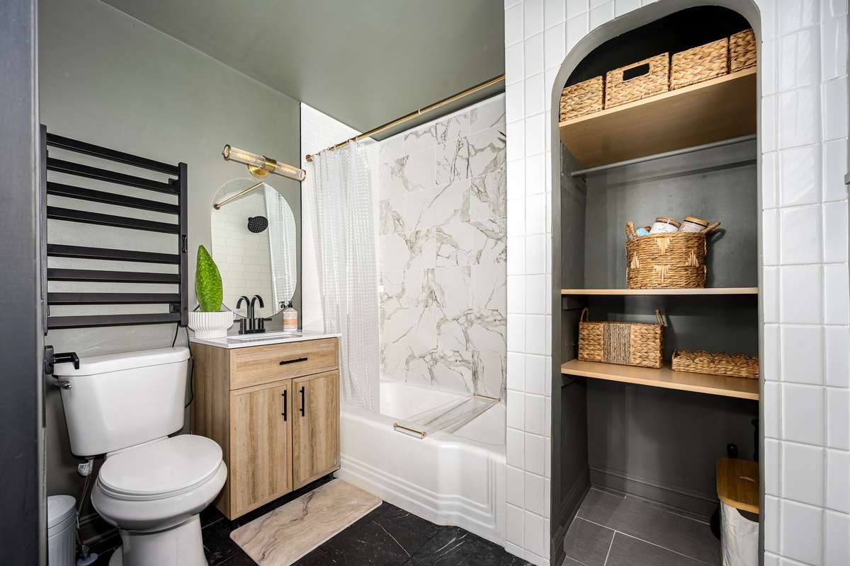 The bathroom is well appointed with spacious storage, tile floor and tile surround bath.