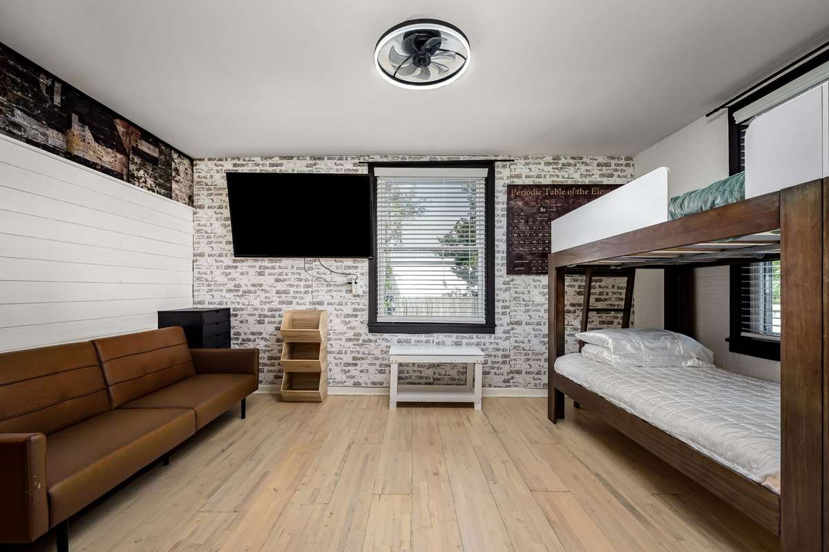 Bedroom 3 has hardwood floors, light fixture with ceiling fan and two windows.