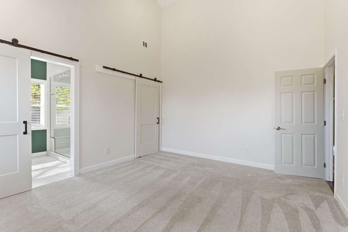 Primary bedroom 1 with walk-in closet and high vaulted ceilings