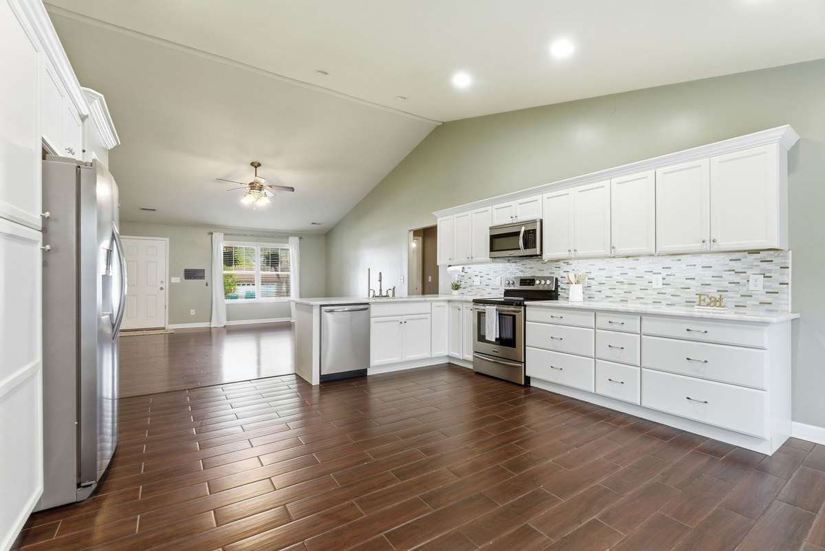 Kitchen has extended cabinets, tiled floor, and  under cabinet lighting.