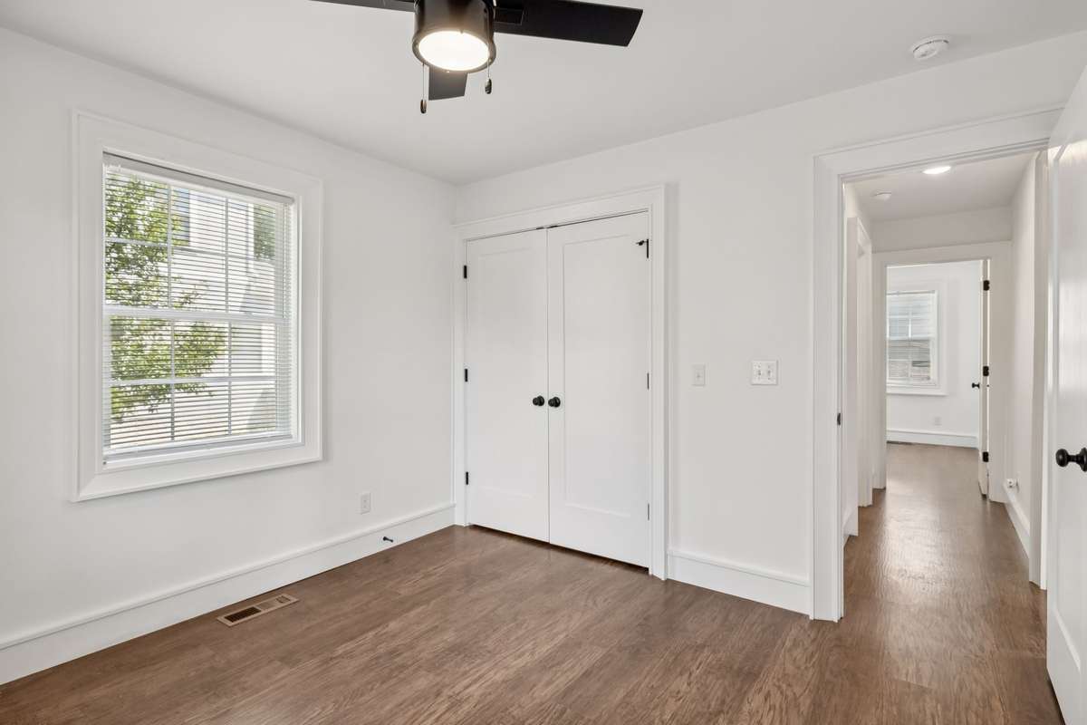 First bedroom on main level offering a spacious closet with custom built-ins for organized living.