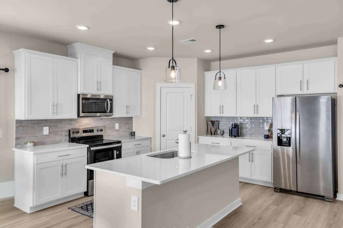 Custom pendant lighting with quartz countertops make this kitchen special